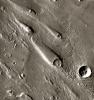 In Ares Vallis, teardrop mesas extend like pennants behind impact craters, where the raised rocky rims diverted the floods and protected the ground from erosion. This image is from NASA's Mars Odyssey, one of an 'All Star' set.