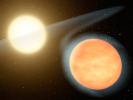This artist's concept shows the searing-hot gas planet WASP-12b (orange orb) and its star. NASA's Spitzer Space Telescope discovered that the planet has more carbon than oxygen, making it the first carbon-rich planet ever observed.