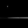 Saturn's rings lie between a pair of moons in this view from NASA's Cassini spacecraft that features Mimas and Prometheus. Mimas is the more noticeable of the two moons at top left, Prometheus is near the center of image and closest to Cassini.