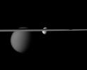 The line of Saturn's rings disrupts NASA's Cassini spacecraft's view of the moons Tethys and Titan. Larger Titan is on the left. Tethys is near the center of the image.