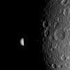 Saturn's moon Mimas peeks out from behind the night side of the larger moon Dione in this image captured by NASA's Cassini spacecraft during the Dione flyby of Dec. 12, 2011.