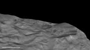 The south pole of the giant asteroid Vesta reveals cliffs that are several miles or kilometers high, deep grooves, and craters. This oblique view is from NASA's Dawn spacecraft.