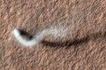 A towering dust devil casts a serpentine shadow over the Martian surface in this image from NASA's Mars Reconnaissance Orbiter. The scene is a late-spring afternoon in the Amazonis Planitia region of northern Mars.