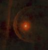 The red supergiant star Betelgeuse (center) is surrounded by a clumpy envelope of material in its immediate vicinity in this view from the Herschel Space Observatory.