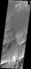 This image from NASA's Mars Odyssey spacecraft shows the southeastern rim of Gale Crater. The large ridge at the bottom of image is the top of the rim. Image shows a channel dissecting the rim; two dune fields occur along the path of the channel too.