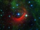 The red arc in this infrared image from NASA's Spitzer Space Telescope is a giant shock wave, created by a speeding star known as Kappa Cassiopeiae.