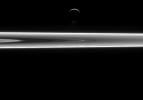 Enceladus' famous south polar water jets can be seen just above the moon's dark, southern limb in this image captured by NASA's Cassini spacecraft.
