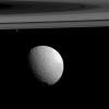Two of Saturn's moons, Tethys and the much smaller Janus, are captured in this photo from NASA's Cassini spacecraft.
