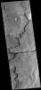 This image captured by NASA's 2001 Mars Odyssey spacecraft shows a graben cutting through a plateau. The graben is part of Sirenum Fossae.