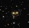 This image from the NASA/ESA Hubble Space Telescope shows a galaxy cluster, SDSS J1038+4849, that appears to have two eyes and a nose as part of a happy face. The 'face' is the result of gravitational lensing.