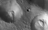 This image from NASA's Mars Reconnaissance Orbiter of craters near Nilokeras Scopulus shows two pits partially filled with lumpy material, probably trapped dust that blew in from the atmosphere.