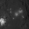 The iconic bright spots of Occator Crater are seen up close in this image of Ceres. This image from NASA's Dawn spacecraft reveals a central dome with linear features on and around it.