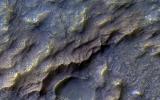In this image from NASA's Mars Reconnaissance Orbiter, the pinkish, almost dragon-like scaled texture represents Martian bedrock that has specifically altered into a clay-bearing rock.