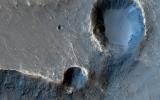 In this image from NASA's Mars Reconnaissance Orbiter, these two craters perched at the edge of an outflow channel, appear to have lost a portion of their crater rims during a flood event.