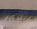 A cross-section of a thick sheet of underground ice is exposed at the steep slope (or scarp) that appears bright blue in this enhanced-color view from NASA's Mars Reconnaissance Orbiter.