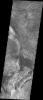 This image captured by NASA's 2001 Mars Odyssey spacecraft shows part of western Candor and the erosion of a large mesa. Layered materials are visible throughout the image.