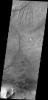 This image captured by NASA's 2001 Mars Odyssey spacecraft shows the eastern end of Ius Chasma. The southern canyon wall is at the bottom of the image, with dark sand and sand dunes.