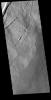 This image from NASA's Mars Odyssey shows the eastern flank of Pavonis Mons where it meets the surrounding volcanic plains. The arced features toward the top are fractures and lava tubes that were revealed by collapse of the roof of the tube into the unde