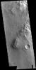 This image from NASA's Mars Odyssey shows Melas Chasma. The linear and arcuate features at the top of the image are on the surface of a large landslide.