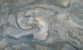 In the center of this JunoCam image, small, bright pop-up clouds seen rise above the surrounding features. Clouds like these are thought to be the tops of violent thunderstorms responsible for shallow lighting.