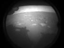 This is one of the first images NASA's Perseverance rover sent back after touching down on Mars on Feb. 18, 2021. The view, from one of Perseverance's Hazard Cameras, is partially obscured by a dust cover. The rover's shadow can be seen at left.