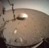 NASA's InSight lander used a scoop on its robotic arm to begin trickling soil over the cable connecting its seismometer to the spacecraft on March 14, 2021. Scientists hope insulating it from the wind will make it easier to detect marsquakes.