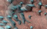 This image acquired on July 22, 2022 by NASA's Mars Reconnaissance Orbiter shows sand dunes moving across the landscape. Winter frost covers the colder, north-facing half of each dune.