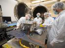 Engineers prepare a small rover – part of NASA's CADRE technology demonstration – for testing in the thermal vacuum chamber behind them at the agency's Jet Propulsion Laboratory in Southern California in October 2023.