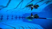 A prototype of a robot designed to explore subsurface oceans of icy moons is reflected in the water's surface during a pool test at Caltech in September, 2024.